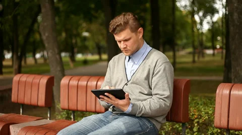 Young businessman working on tablet computer in city park, 1080p Stockbeeldmateriaal 28505187