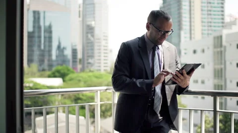 Young businessman working on tablet computer standing on the terrace  HD Stock Footage 51432724