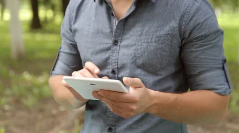 Young businessman working on tablet computer in the park Stock Footage