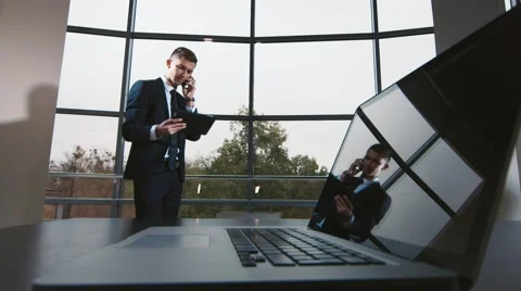 Young businessman working with the tablet: talking on a cell phone Stock Footage 56285577