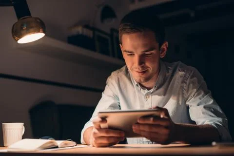 Young businessman working using a tablet late at night Stock Photos
