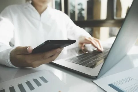 Young businessman working using texting cell phone typing computer Stock Photos