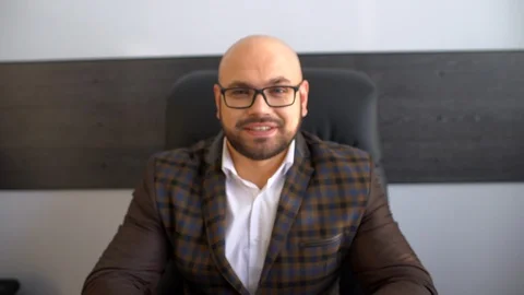 Young businessman at the workplace is looking at the camera and smiling. Stock Footage 86674517