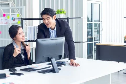 Young businesspeople analyzing information through computers and brainstorm w Stock Photos