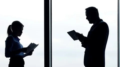 Young businesspeople comparing data on tablet computer and documents in office Stock Footage 76150311
