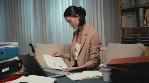 Young Businesswoman Comparing Data on Computer and Paper Working at Office Stock Footage 248825819