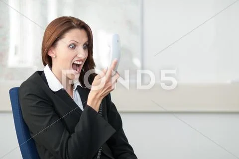 Young businesswoman shouts into the phone Stock Photos