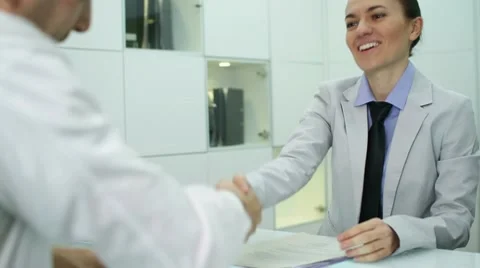 Young businesswoman signing contract with male client Stock Footage