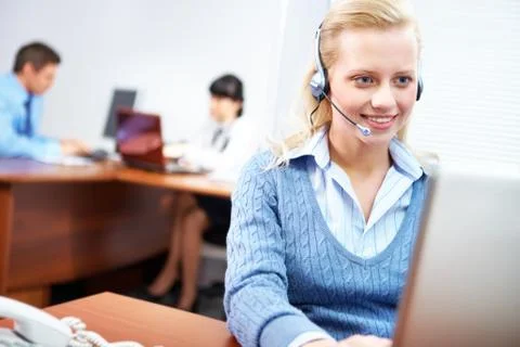 A young businesswoman sitting in headset at the laptop Stock Photos
