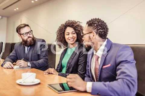Young Businesswoman Talking At Conference Table Meeting With Businessmen