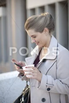 Young Businesswoman Texting On Smartphone In City