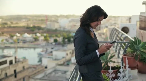 Young businesswoman using smartphone on terrace, crane shot HD Stock Footage