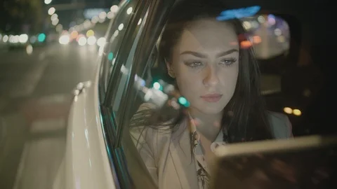 Young Businesswoman Using a Tablet Computer in the Moving Car Stock Footage 97956944