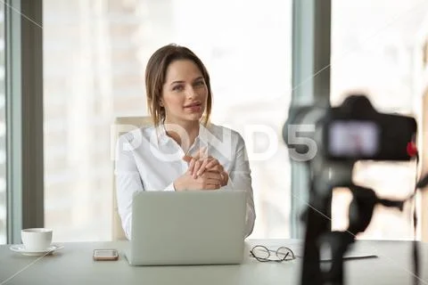 Young businesswoman vlogger recording vlog talking to camera in Stock Photos