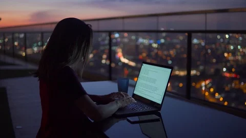 Young Businesswoman work on notebook computer on the balcony of a skyscraper on Stock Footage