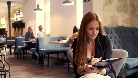 Young busisnesswoman doing notes in cafe Video stock 86085604