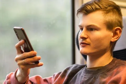 Young busy man using smartphone when he traveling by train. Man sits at the Stock Photos