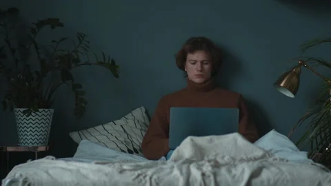 Young calm programmer is working at home at bed, freelance creating product Stock Footage 146309784