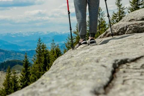 Young, carefree boy climbing up solid huge rocks, using poles to make it easy Stock Photos