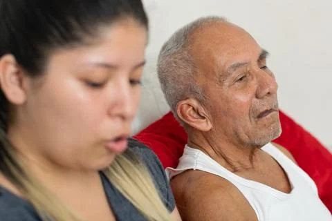 Young caregiver speaking while elderly grandfather listens showing communic.. Фото