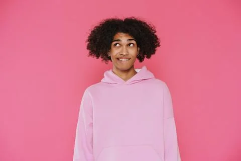 Young caribbean man with piercing looking aside while biting his lip Stock Photos