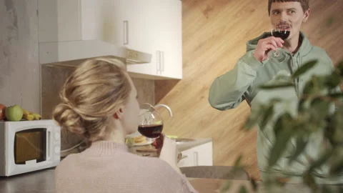 A young caring husband prepares a festive dinner and drinks wine and talks to Stock Footage 145081315