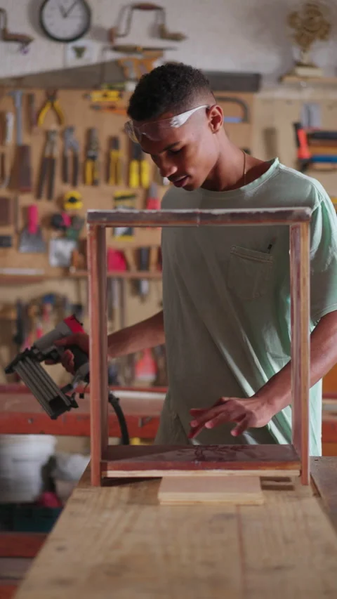 Young carpenter apprentice working at carpentry workshop with drilling tool.. Stock Footage 247150069