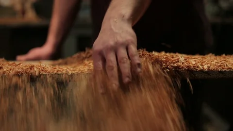 Young carpenter cleans up his full of sawdust workbench, after a day of work. Stock Footage 100763988