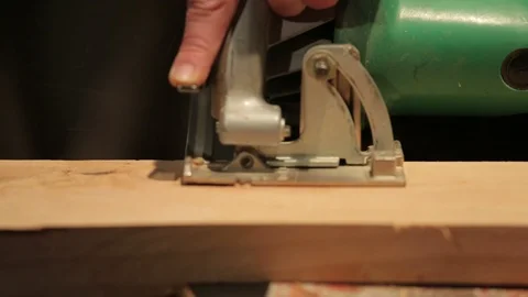 Young carpenter cutting a block of wood with the circular saw Stock Footage 100977988
