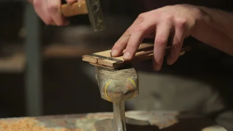 Young carpenter hammers a flat bracket on some boards of wood Stock-Footage 100983124