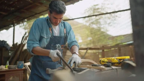 Young carpenter man using saw to cut timber during woodworking in the workplace. Stock-Footage 263111247