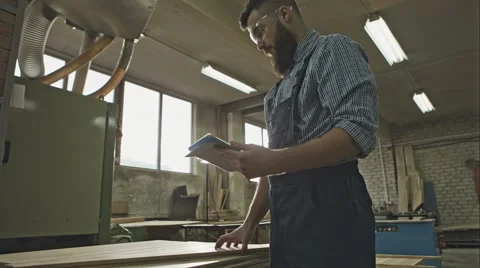 Young carpenter with the tablet quality control material. RAW video rcord Stock-Footage 61094014