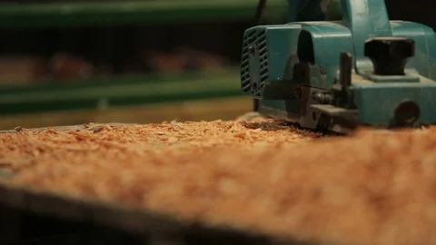 Young carpenter takes the planer and starts to work on a block of wood. Stock-Footage 100762673