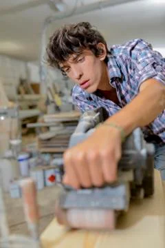 Young carpenter using a belt sander Stock Photos