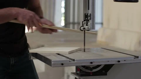 Young carpenter working on a teble saw marking and cutting a wooden plank Video stock 173937672