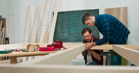 Young carpenters build a solid wood wall in a carpentry workshop. Stock Footage 144090177