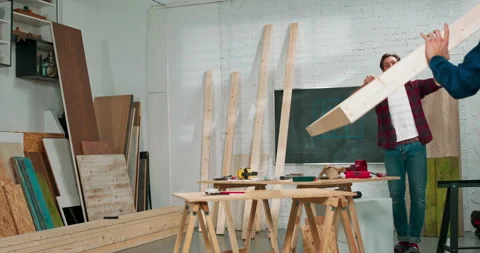 Young carpenters build a solid wood wall in a carpentry workshop. The carpenters Stock Footage 144090394