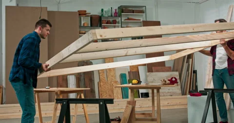 Young carpenters build a solid wood wall in a carpentry workshop. The carpenters Stock Footage 144090710