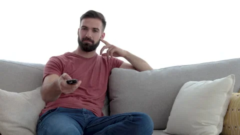 Young casual man changing the channels on the tv or television remote control Video stock 132648081
