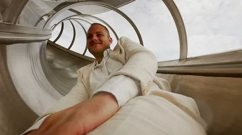 Young casual man having fun sliding down on slide in slow motion. carefree Stock Footage 42945753