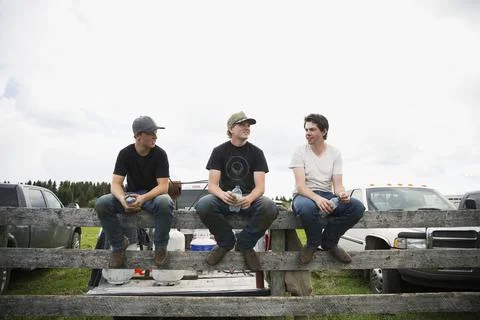 Young cattle ranchers taking a break on fence Stock Photos