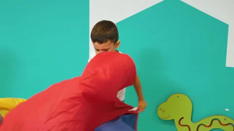 Young caucasian boy jumping with joy waving play parachute then stopping to look Stock Footage 219514732