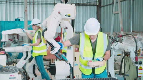 Young caucasian engineer man using remote control with ai robot machine arm.. Stock Footage 232309325