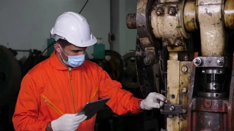 Young Caucasian engineer or worker inspecting heavy industry machinery Stock Footage 147333537