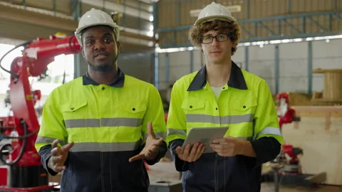 Young Caucasian engineer is presenting and explaining how a robotic arm Stock Footage 196035689