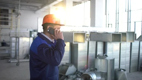 Young caucasian engineer talking on the phone at the building under construction Stock Footage 85822087