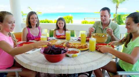 Young Caucasian family dining on vacation beach hotel decking Stock Footage