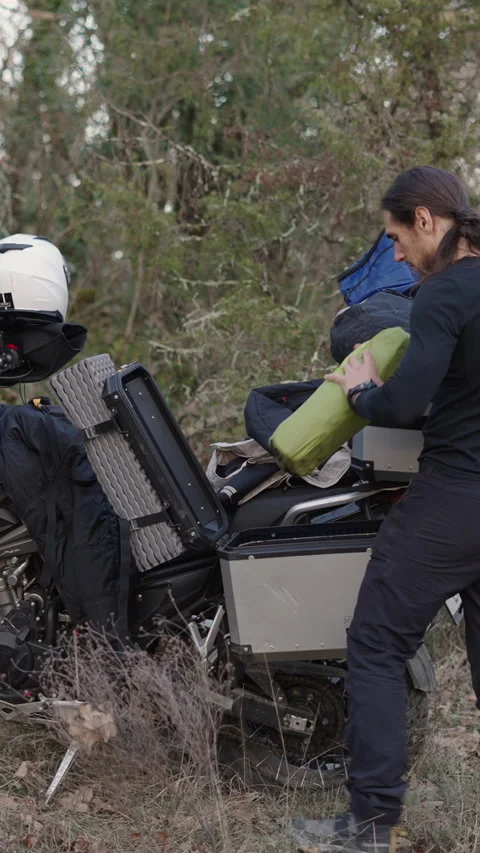 Young caucasian guy in the forest taking the tent out of a suitcase on his Stock-Footage 276183965
