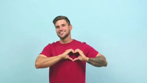 Young caucasian handsome man doing a heart with hands, expressing the concept of Stock Footage 138661809