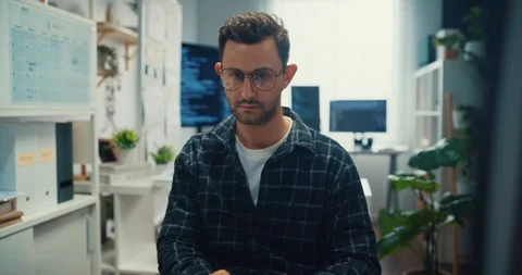 Young Caucasian male programmer writes code using computer in office. Stock Footage 344036052